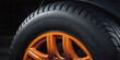 Close-up of a car wheel with metallic orange rim