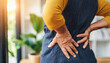 elderly woman's hands clutching her aching back, symbolizing pain and discomfort