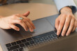 © Uri Prat - Hands of an executive woman dressed formally in a light blue shirt typing on her laptop