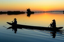  A Tranquil Scene Of Cambodian Fishermen In Small Wooden Boats On The Tonle Sap Lake, With Floating Villages In The Background, Generative AI