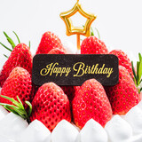 Fototapeta Zachód słońca - Delicious birthday cake with fresh strawberries, on wooden table and white background. Free space for your text.