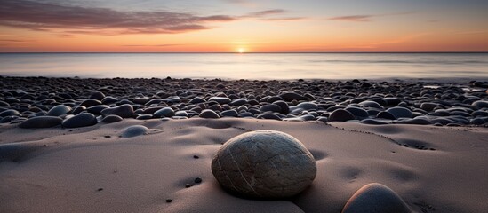 Sticker - A Stone in the sand looks like a mediation calm view of the beach at sunset