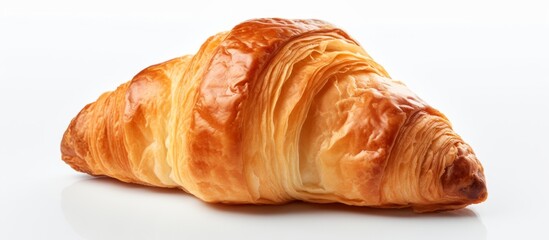 Sticker - A close up of a croissant, a popular French baked good, on a white surface. This flaky pastry is a delicious and iconic dish in French cuisine