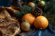 Citrus fruits next to an ornament, featuring a festive atmosphere in a color palette of dark blue and amber.