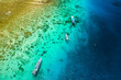 Tourist boats over a tropical coral reef at low tide on the coast of a small tropical island (Gili Air, Indonesia)