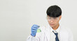 © Singh - Portrait asian man student scientist or doctor look hand holding reagent mixing laboratory in science research laboratory with test tubes of various size in  laboratory chemistry lab white background