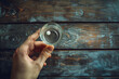 Hand holding a glass of water on a wooden background