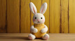 Happy Easter concept greeting card - Cute knitted easter bunny, cuddly toy, on yellow painted wooden table, wood background texture, top view, flat. generative.ai