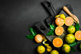 Fototapeta Desenie - Fresh ripe Tangerine orange. Top view, on a dark stone background. Autumn fruits.