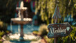 A wooden 'Wedding' sign with a heart on it in a sunny garden setting