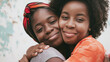 © BONI - Retrato de Dos mujeres negras madre e hija de pie abrazadas y sonriendo juntas.