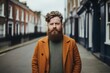 Portrait of a handsome bearded hipster man in a yellow coat on a city street.