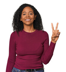 Wall Mural - African American woman in studio setting showing victory sign and smiling broadly.