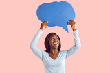 Fototapeta Natura - Happy excited young african american woman holding blank speech bubble for thoughts isolated on pink studio background. Girl with empty word cloud offering space for text. Idea concept.