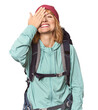 Middle-aged Caucasian woman with hiking gear having fun covering half of face with palm.