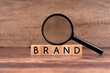 Brand word on wood block with magnifying glass