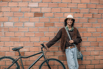 Wall Mural - young man leaning on street wall with bike