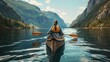 A person is actively paddling a canoe on a lake with majestic mountains in the background