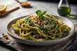 Frische Pesto-Spaghetti mit Pinienkernen und Parmesan auf elegantem Teller