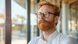Handsome 45 years old gentle caucasian ginger red hair man, wearing glasses, formal slick hairstyle, smooth face in a modern office building, wearing white shirt, beside a huge window