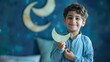 A young boy joyfully holding a paper crescent moon with his hand painted wishes for a happy and prosperous Ramadan.