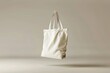 a white tote bag hanging from a wall