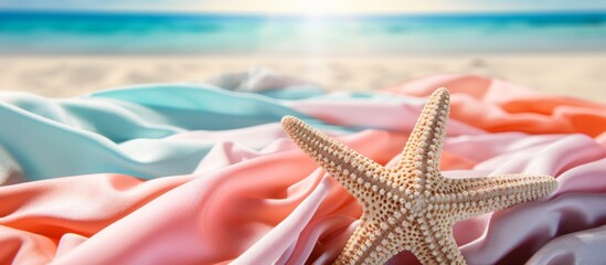 Canvas Print - An electric blue starfish rests on towels at the beach, surrounded by terrestrial plants. The carmine horizon meets the ocean in this stunning landscape