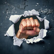 © Image-Love - A fist is shown through a hole in a wall. The fist is clenched and the hand is extended. Concept of power and strength