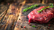 Raw meat displayed on weathered wooden table surface.