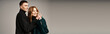 © LIGHTFIELD STUDIOS - joyful appealing couple in elegant coats smiling and having quality time on gray backdrop, banner