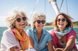 a group of older women wearing sunglasses sit on a sailing boat