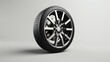 3D rendering of a single black alloy wheel with a tire on a white background.