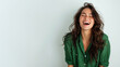© pariketan - Brunette woman wearing green shirt smiling laugh out loud isolated on grey