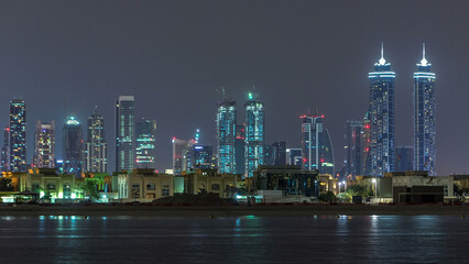 Poster - Modern Dubai city skyline timelapse at night with illuminated skyscrapers over water surface