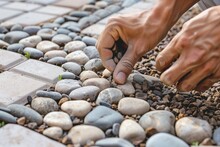 Closeup Of Person Placing Decorative Pebbles Around Pavers