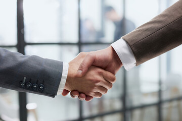 Wall Mural - close-up of a handshake of business partners against the background of colleagues