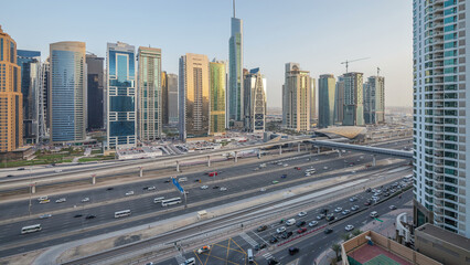 Wall Mural - Aerial view of Jumeirah lakes towers skyscrapers day to night timelapse with traffic on sheikh zayed road.