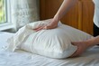 person placing a freshly laundered cover on an orthopedic pillow