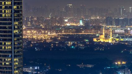 Wall Mural - Skyline view of Deira and Sharjah districts in Dubai timelapse at night, UAE.