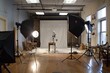 © Ilia Nesolenyi - A commercial photography studio setup with bright lights, lighting equipment, backdrops, and props being prepared for a session