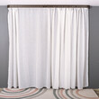 The white curtain hangs in folds. The waves of the fabric are transparent and clean.