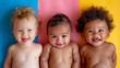 Cheerful babies of different ethnicities in diversity photo shoot on soft color background.