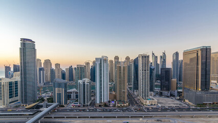 Wall Mural - Dubai marina with traffic on sheikh zayed road panorama day to night timelapse lights turn on.