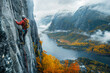 A climber climbs a vertical rock face, in the background a spectacular autumn landscape