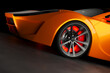 Exquisite Orange Luxury Sports Car Showcased Under Dramatic Studio Lights