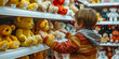 A boy arranges stuffed animals on shelves, playing the role of a toy store manager ,