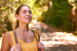 Fototapeta  - Young Woman Wearing Backpack Closing Eyes Enjoying Peace Of Hike Along Trail Through Countryside