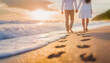 Handheld couple walking barefoot on the beach leaving footprints in the sand and foamy waves washing the shore in the morning at sunrise