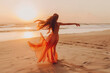 A beautiful young girl in a yellow dress dancing on the beach. The concept of a good mood, vacation, seaside vacation.