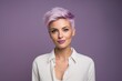 Portrait of beautiful young woman with short pink hair, on purple background